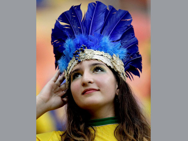 A spectator adjusts her headdress before the start of the group A World Cup