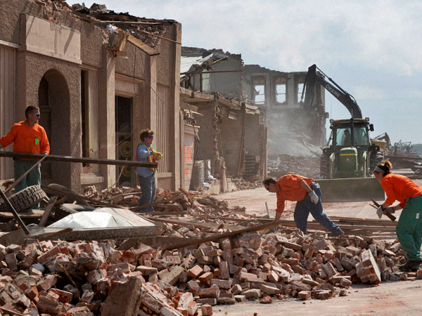 Workers clean up debris from a property in Pilger