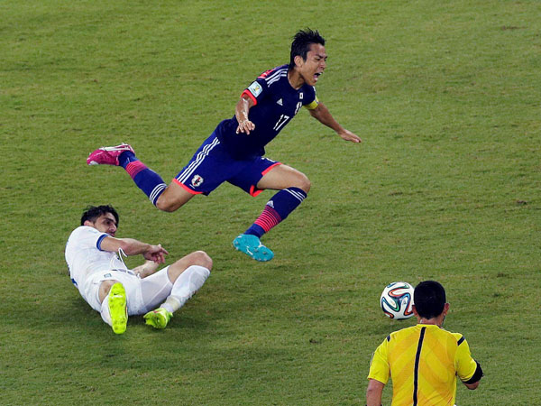 Greece's Kostas Katsouranis, left, fouls Japan's Makoto Hasebe