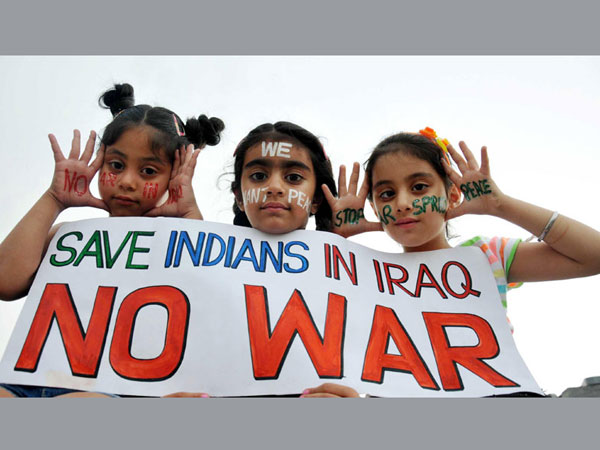 Children hold a placard reading 'Save Indians in Iraq - No War'