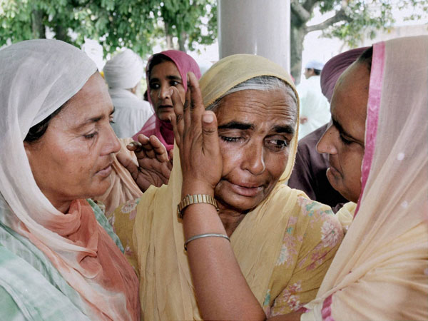 A relative is consoled during a prayer meeting for the Indian workers