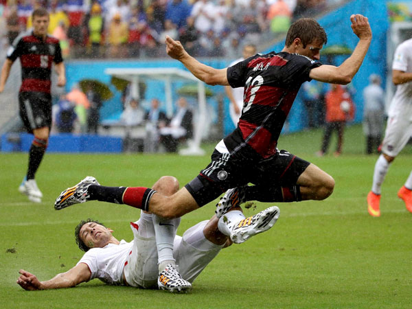 Germany's Thomas Mueller is tripped by United States' Omar Gonzalez 