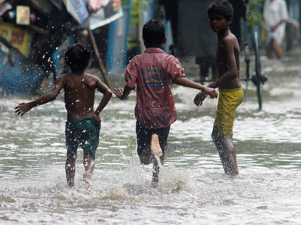 hildren enjoy themselves in waterlogged roads 