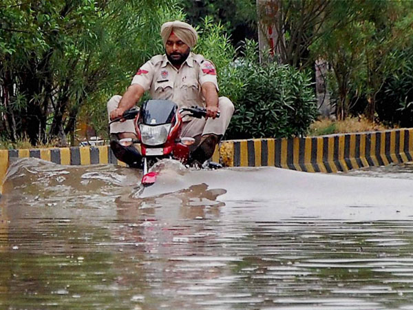 A police officer rides through flooded street 