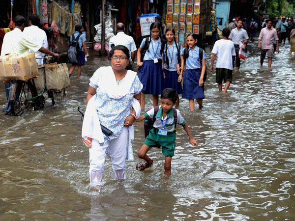 People wade through a water logged street 