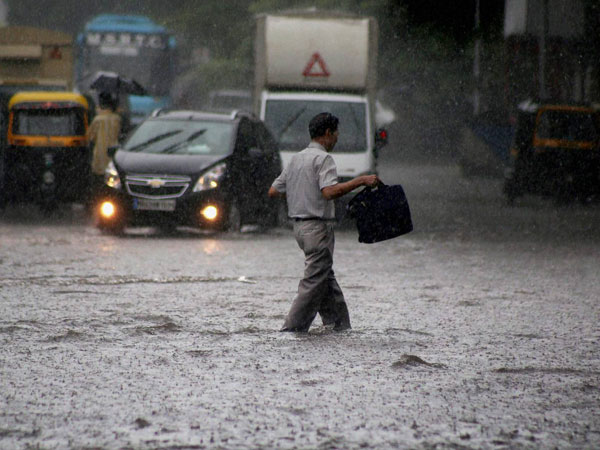 Vehicles move through a waterlogged road