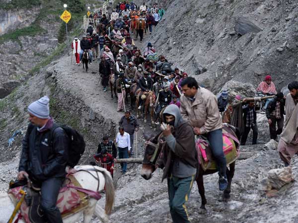Pilgrims climb the hilly terrain on horse back
