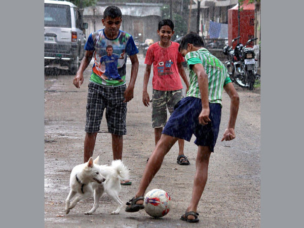 Young boys playing a game of football in rains