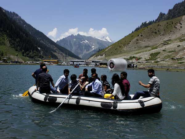 Tourists enjoy themselves aboard a raft on a spectacular blue water lake Tourists enjoy themselves aboard a raft on a spectacular blue water lake