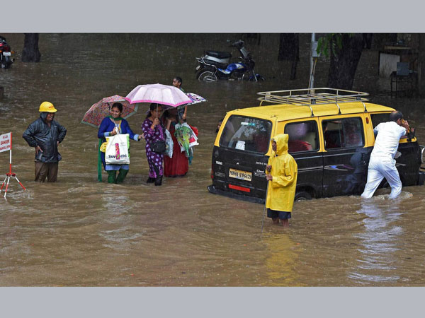 People wade through a waterlogged street
