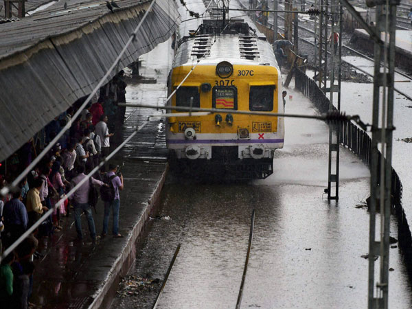 A local train wades chugs at a waterlogged railway track