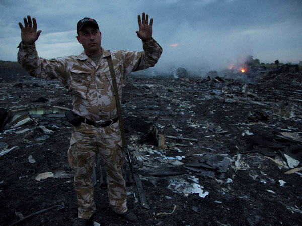 A man gestures at a crash site of a passenger plane 
