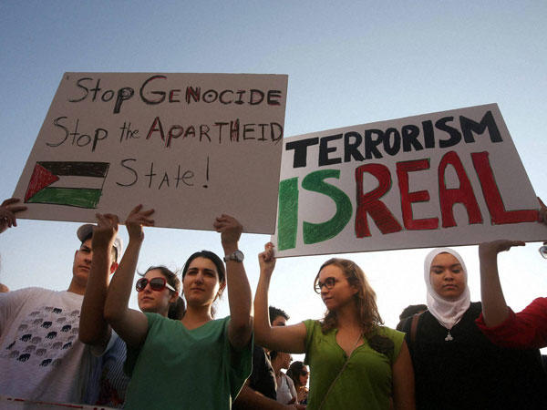 Lebanese and Palestinians hold up placards during a protest