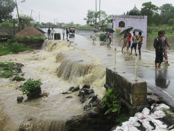 People cross flooded Machna river after heavy rains 