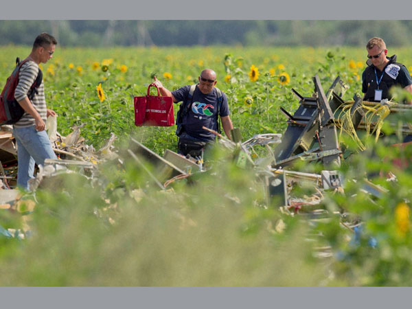 A Malaysian air crash investigator holds a bag