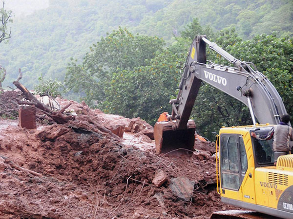 Rescue workers clear the debris at the site of landslide