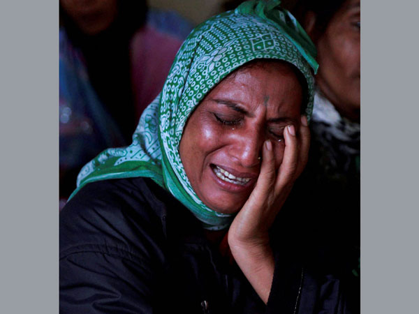 Relatives wail after seeing the body of a victim