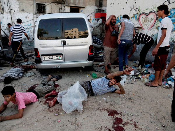 Injured Palestinian men lay on the ground following an Israeli Strike 