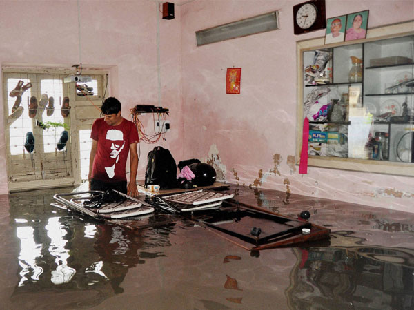 An army man in his flooded room in Ahmedabad