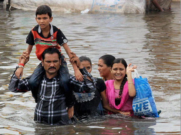 A family shifting from a flooded locality after heavy rains