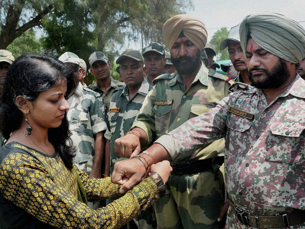 A girl ties rakhi on the wrist of a BSF soldier