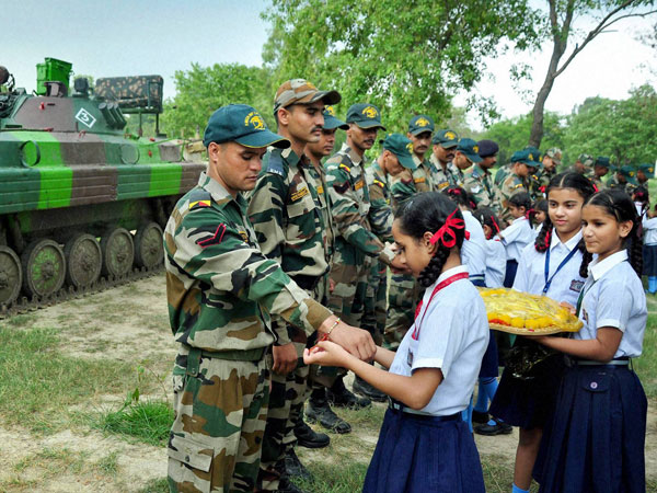 School girls tie rakhi on the wrists of Army soldiers