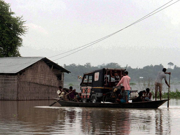 Villagers carry an auto rickshaw on a boat to safer areas Villagers carry an auto rickshaw on a boat to safer areas