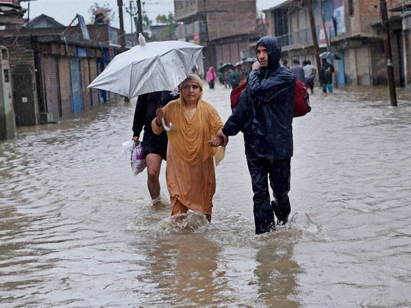 People wade through a street flooded