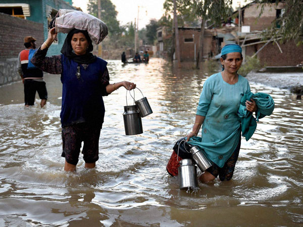 Flood victims walk through the flooded path