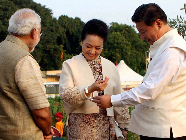 Chinese President Xi Jinping and his wife Peng Liyuan being presented a traditional bangle