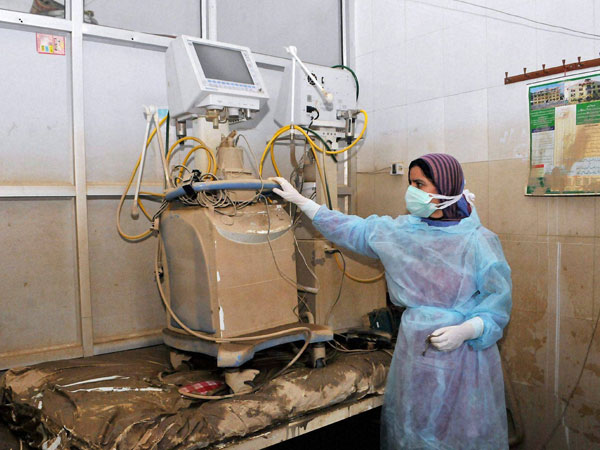 A hospital staff member looks at the damaged ventilator