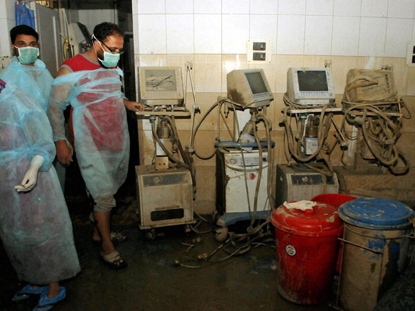 Hospital staff look at the damaged ventilators