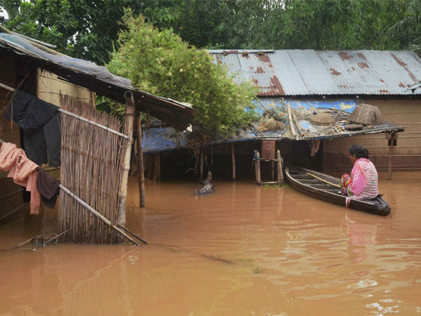 A woman sitting in a boat outside her house