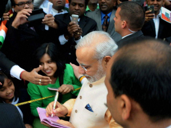 Modi giving autographs to children