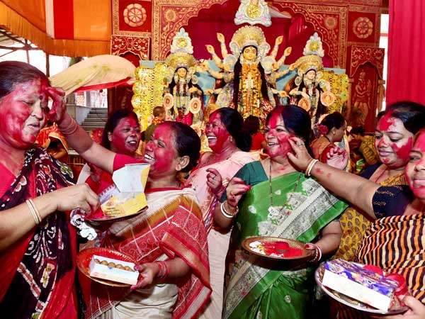Married Bengali women play with vermillon powder