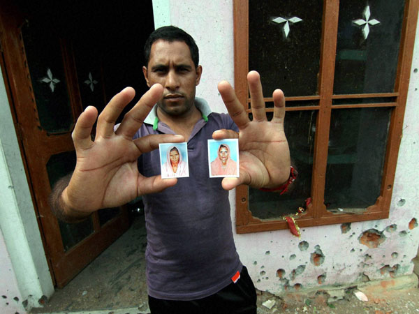 A man shows the picture of two women reported to have been killed