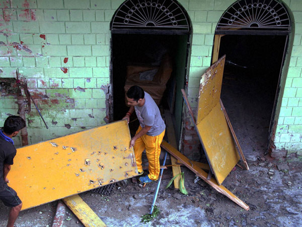 Men carry damaged ply woods after shelling