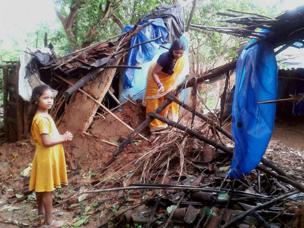 A woman salvaging her belongings at her damaged house 