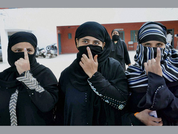 Burqa clad voters shows their inked fingers