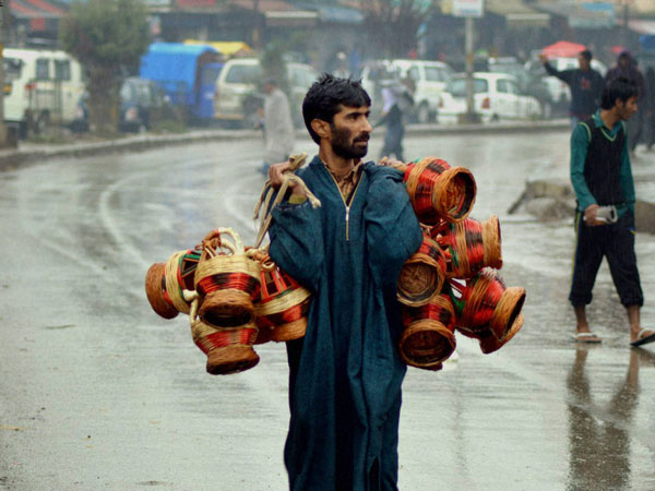 A vendor carrying Kangrir, a traditional fire-pot