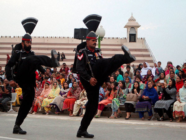 Pakistani border guards perform high kicks during a flag