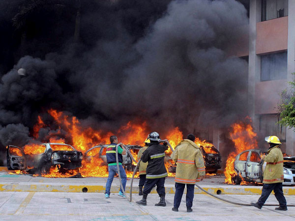 Firefighters try to extinguish burning vehicles