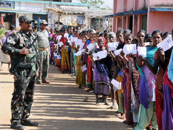 A security person stands guard as voters