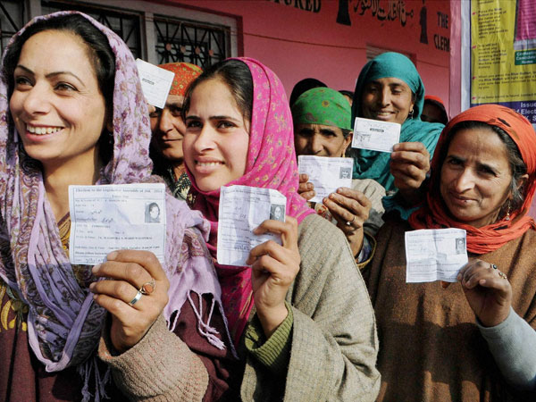 Women wait to cast their votes at a polling station 