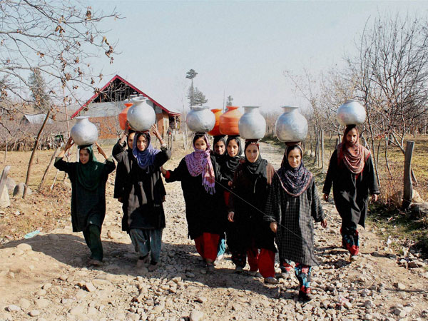 Kashmiri girls carry vessels with drinking water Kashmiri girls carry vessels with drinking water