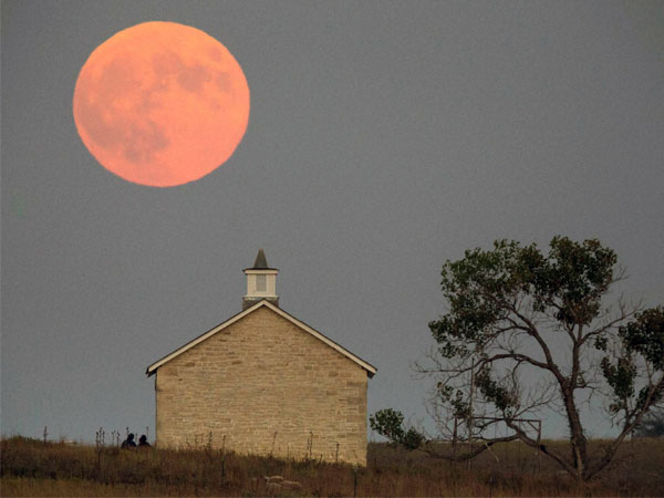 Strong City : A super moon rises over the Lower Fox Creek School near Strong City, Kan., Sunday, Sept. 27, 2015. It was the first time Sunday since 1982 that a total lunar eclipse was combined with a supermoon. 