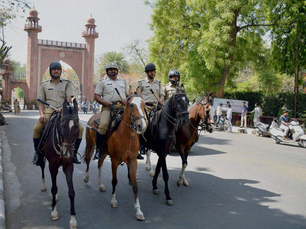 Police force deployed infront of Aligarh Muslim University gate after the clashes between two groups at University campus, in Aligarh on Sunday. 