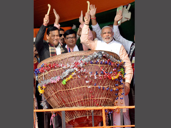 PM Narendra Modi, along with Union Minister and Assam BJP state president Sarbananda Sonowal beats a 'Maadol', the traditional drum of tea tribes, during a public rally at Moran in Dibrugarh district of Assam.