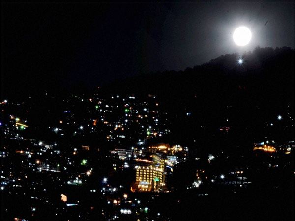 Supermoon peeking through the mountains in Shimla