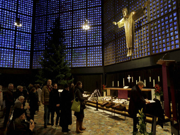 People queue to light candles and sign a book of condolence